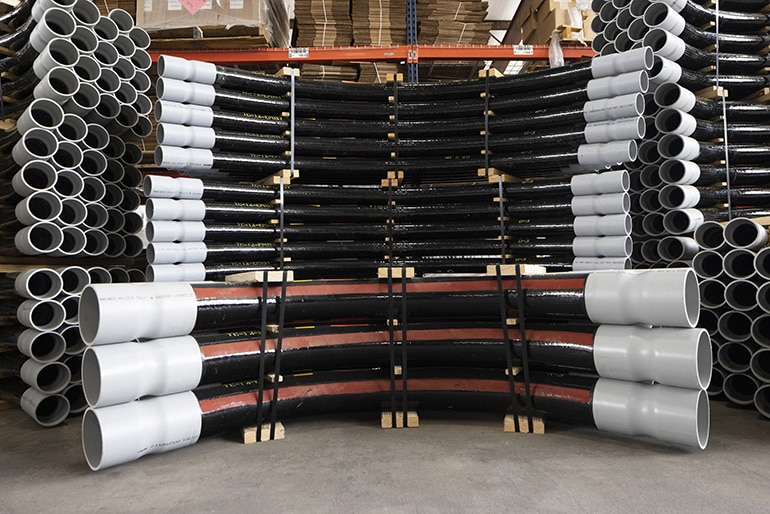 Stacks of fiberglass electrical conduit elbows.