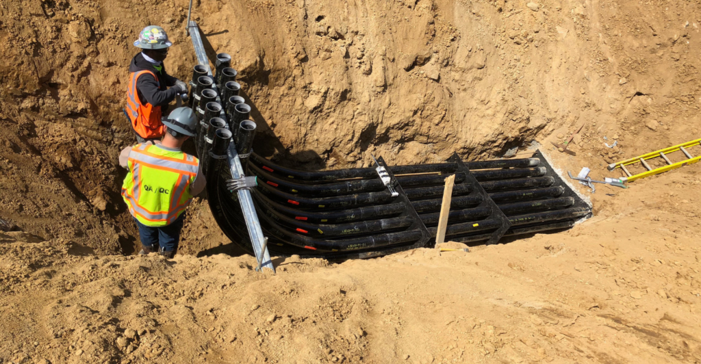 Elbows in ground with two workers