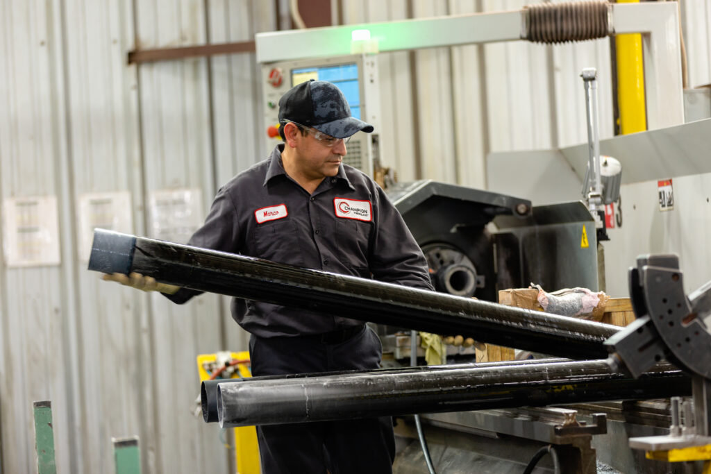 Champiom Fiberglass A Champion Fiberglass manufacturing worker inspects electrical conduit.