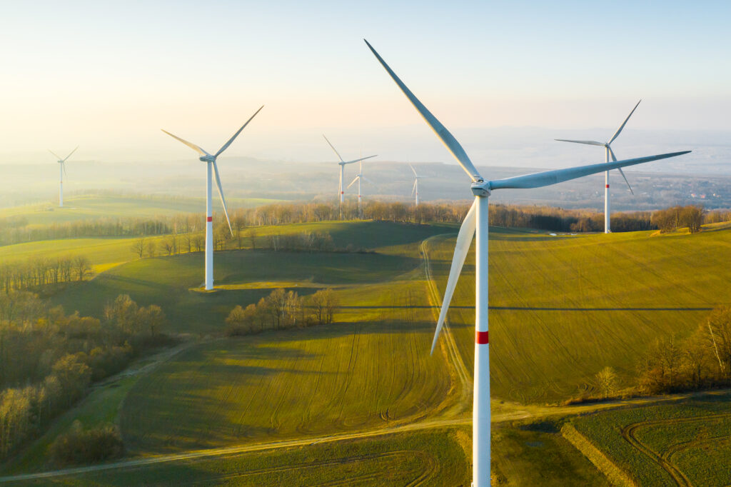 Wind turbines over green rolling hills